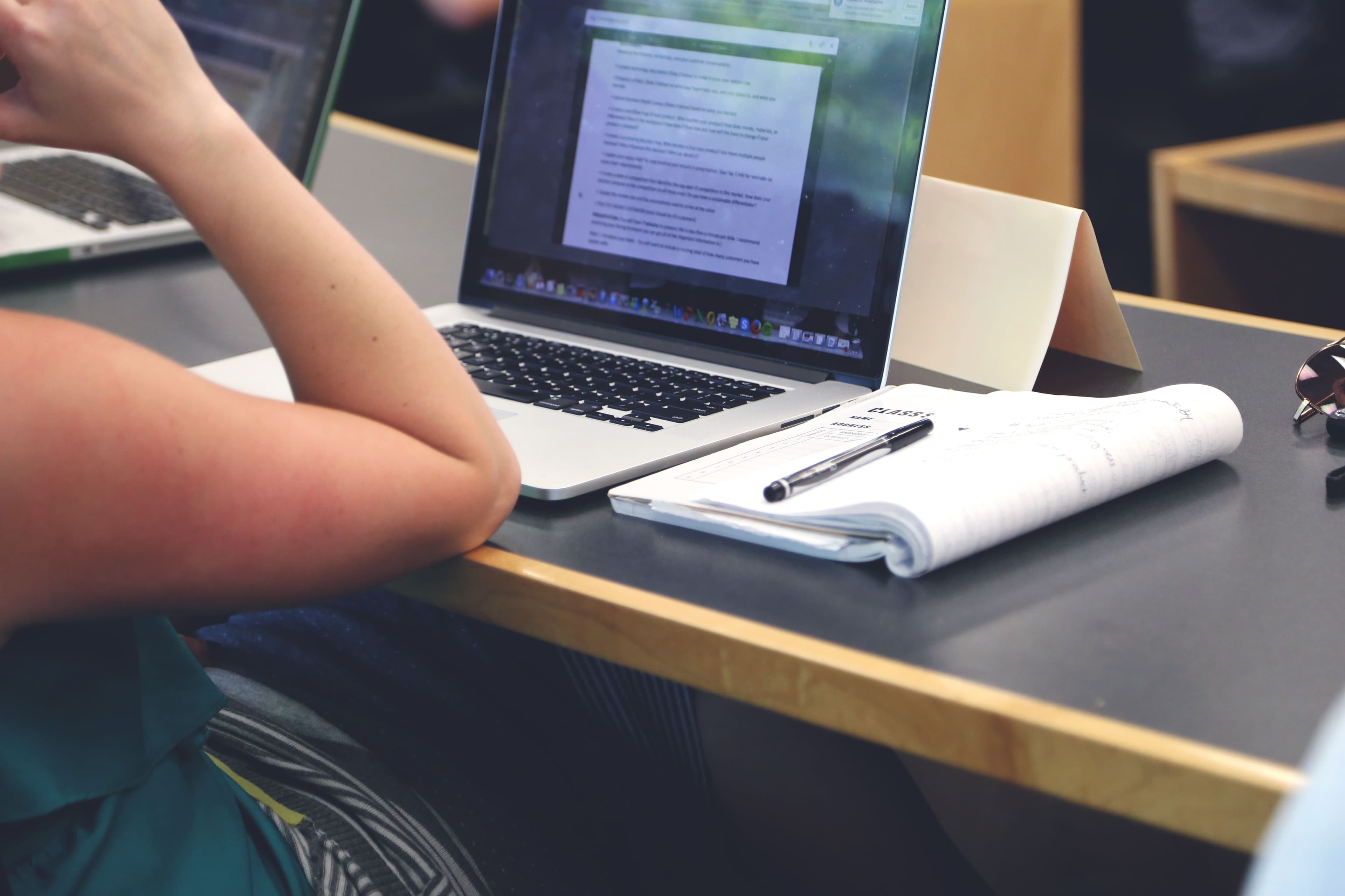 A laptop and books in a university study space representing higher-education technology